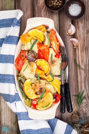 baked chicken with paprika, lemon and estragon on wooden tableの写真素材