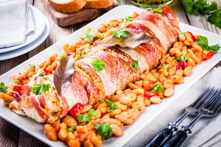 Codfish baked in a jamon with beans, baked paprika and parsleyの写真素材