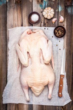whole raw duck ready to cook on wooden tableの写真素材