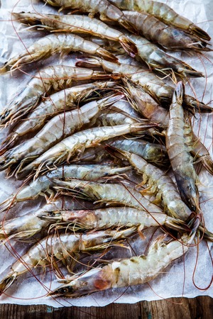 Whole fresh raw shrimps seafood on paper ready to cookの写真素材