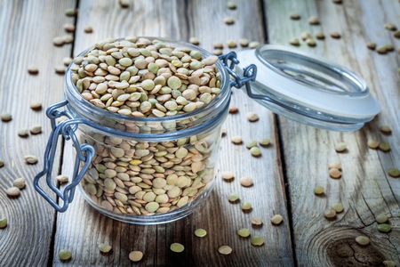 glass jar with organic green lentils on wooden backgroundの写真素材