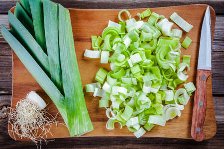 Chopped raw organic leek on a wooden cutting boardの写真素材