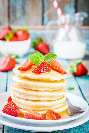 Breakfast: homemade pancakes with honey and strawberriesの写真素材