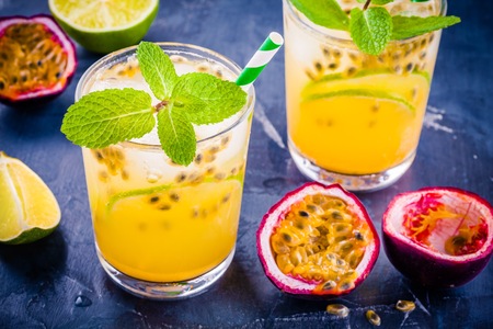 tropical cocktail with passion fruit, lime and mint on a dark backgroundの写真素材