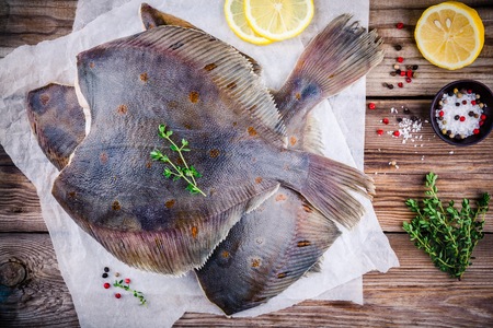 Raw flounder fish, flatfish on wooden background