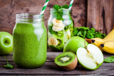 Green healthy  smoothie in  glass jar: banana, kiwi, spinach, green apple on rustic backgroundの写真素材