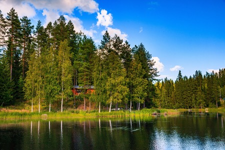 Wooden cottage in summer on the lake in Finlandの写真素材