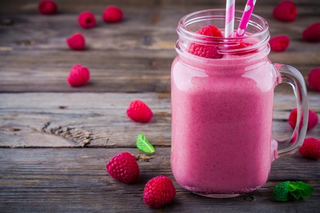 Raspberry smoothie in mason jar on rustic wooden backgroundの写真素材