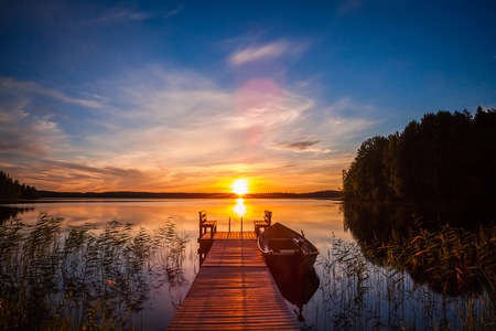 Sunset over the fishing pier at the lake in rural Finlandの写真素材