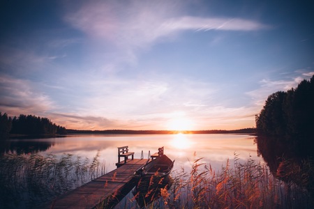 Sunrise over the fishing pier at the lake in rural Finlandの写真素材