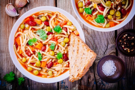 Italian cuisine: Minestrone soup with vegetables and pasta and whole grain toasts.の写真素材