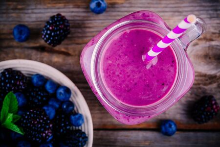 blueberry and blackberry smoothie in mason jar on wooden background. Top viewの写真素材