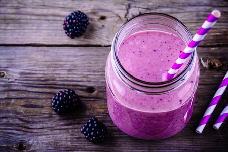 blackberry smoothie in a mason jar on a wooden rustic backgroundの写真素材