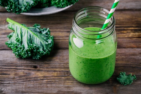 Healthy green smoothie with kale in mason jar on rustic wooden backgroundの写真素材