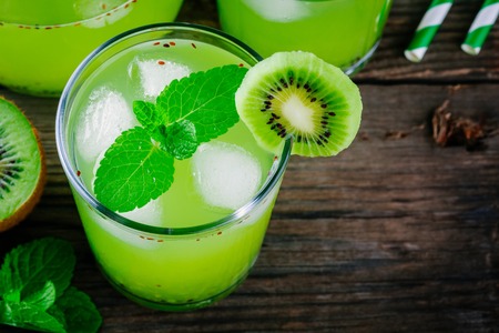 Ice drink with kiwi and mint in a glass on a wooden background.の写真素材