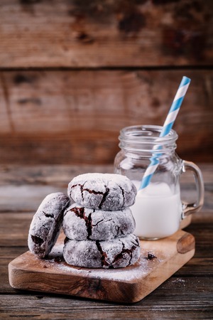 Chocolate crinkle cookies with powdered sugar icing for christmas on wooden backgroundの写真素材