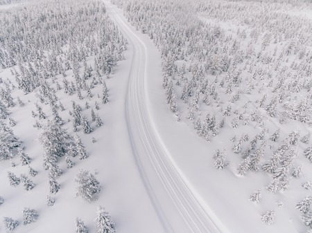 Aerial view of the road in the winter snow forest in Finland, Lapland