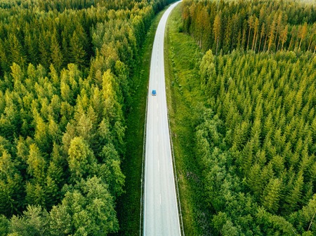 Aerial view from above of country road through the green summer forest in summer Finland. drone photographyの写真素材