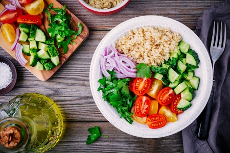 Healthy detox Quinoa Tabbouleh Salad bowl with fresh cucumbers, tomatoes and red onionsの写真素材