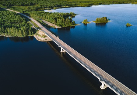 Aerial view of modern bridge across blue lake in summer landscape in Finlandの写真素材