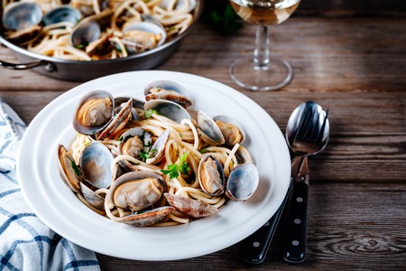 Traditional italian seafood pasta with clams Spaghetti alle Vongole on wooden backgroundの写真素材