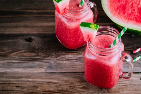 Watermelon smoothie in mason jars with mint on wooden rustic backgroundの写真素材