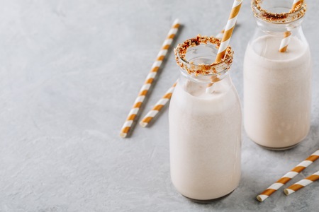 Vanilla cookie milkshake in glass bottles on a gray backgroundの写真素材