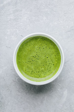 Japanese matcha green tea latte in white bowl on gray stone background. Top viewの写真素材