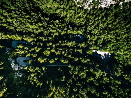 Aerial above view of a rural mountain landscape with a curvy road in Italy. Drone photographyの写真素材