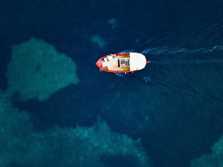 Aerial view of small fishing boat at sea, Greece.