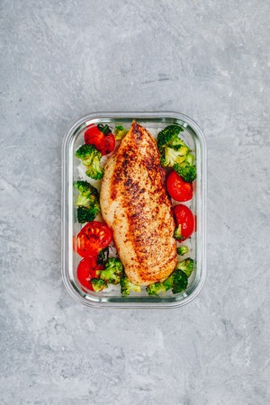 Grilled chicken meal prep containers with rice, broccoli and tomatoes. Healthy lunch with vegetables, copy spaceの写真素材