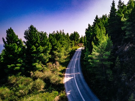 Aerial view overhand the green forest and road in rural Greeceの写真素材