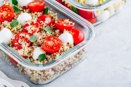Vegetarian meal prep lunch box containers with quinoa, mozzarella cheese, tomatoes and basil.の写真素材