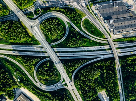 Aerial view of highway and overpass with green woods on a summer day in Finland.のeditorial素材