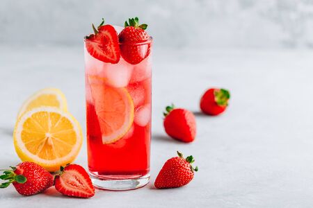 Refreshing Strawberry and lemon Iced Tea or lemonade in glass on a gray stone backgroundの写真素材