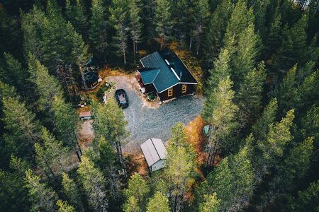 Aerial view of secluded cottage in the woods. Log cabin in the forest in rural Finland. View from above.の写真素材