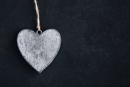 Valentines Day background with heart. Homemade wooden rustic heart on dark blackboard with copy space, top view from aboveの写真素材