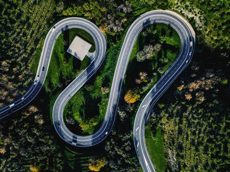 Aerial view of winding curved road with helicopter parking in Italy countrysideの写真素材