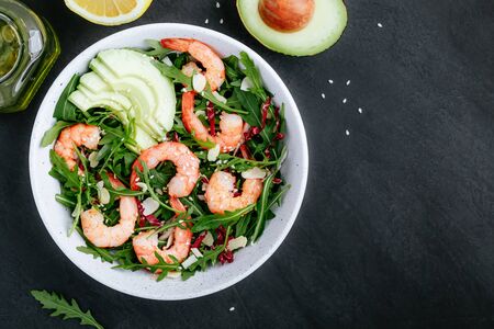 Shrimp salad with fresh green arugula leaves and avocado, radicchio, almond and sesame seeds. Healthy lunch bowl salad.の写真素材