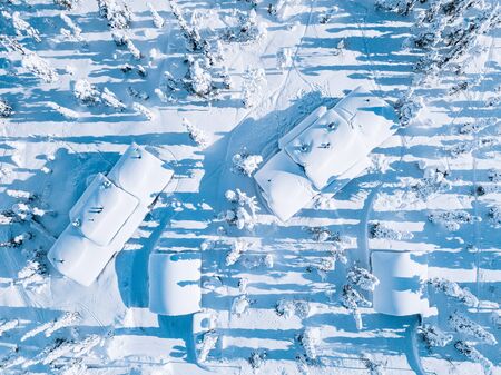 Aerial view of wooden log cabin and snow covered trees in winter Finland Lapland. Drone photography...