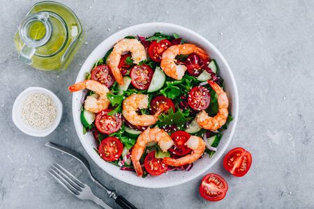 Shrimp salad with fresh green lettuce and radicchio leaves, cucumbers, tomatoes and sesame seeds. Healthy lunch bowl salad.の写真素材