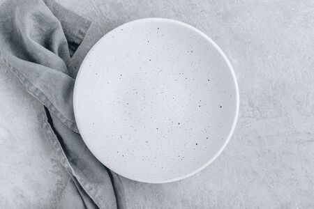 Empty white plate on gray concrete stone background. Top view, copy spaceの写真素材