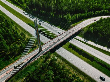 Aerial top view of cable-stayed Suspension bridge and Highway road with green forests on a summer...
