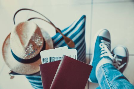 Woman holding passport with boarding pass close up at airport waiting the flightの写真素材