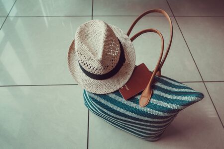 Passport on the travel bag with hat close up at airport