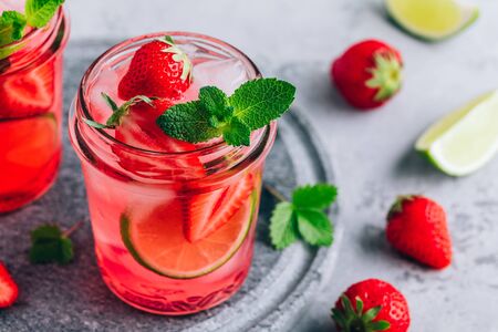 Strawberry lime lemonade with fresh mint and ice in glass jar. Summer refreshing drink.の写真素材