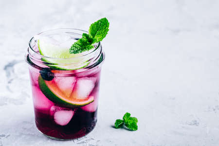 Blueberry Mojito with lime and fresh mint. Iced cold summer drinks in glass jar.の写真素材