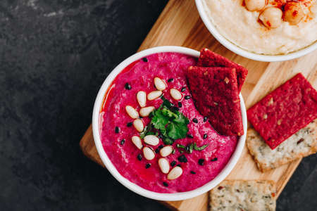 Beetroot Beet Hummus with crispbread. Healthy vegan dip on dark stone background, copy space.の写真素材