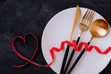 Valentine's Day table setting with red ribbon on darkの写真素材