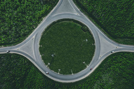 Aerial view of a traffic roundabout and road junctions in green summer forestの写真素材